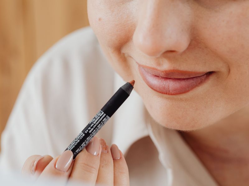 Smiling woman holding a lip liner pencil