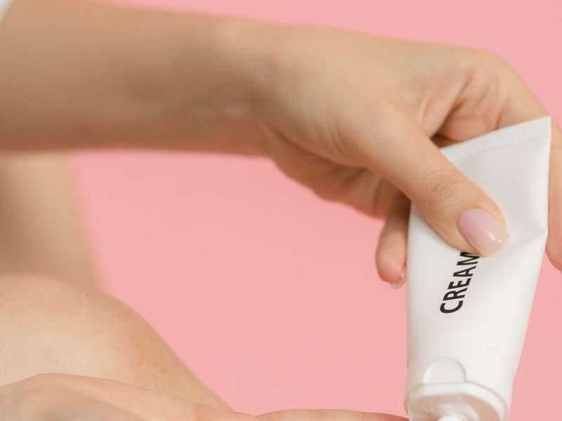 Hand holding a tube of cream