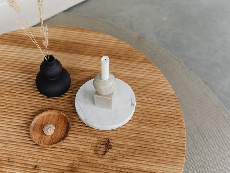 Round wood table with a vase and candle holder