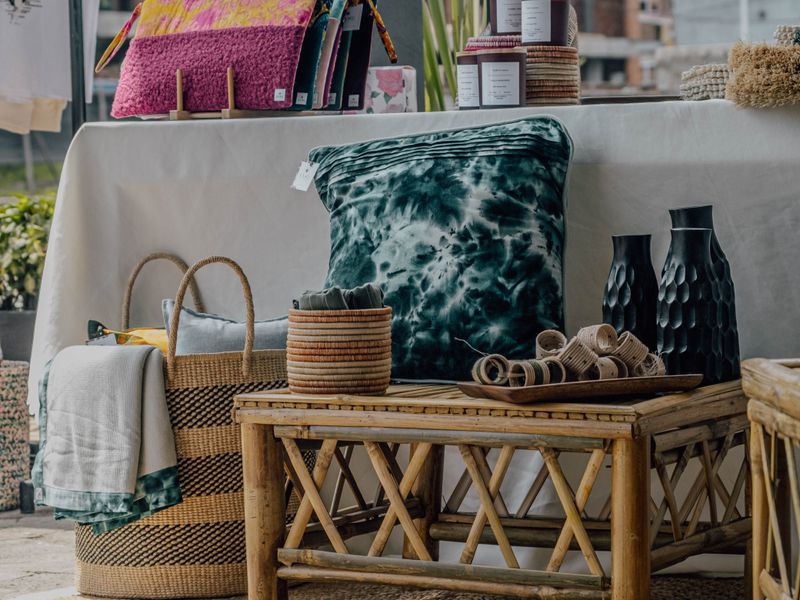 Rattan side table with woven baskets and dark vases