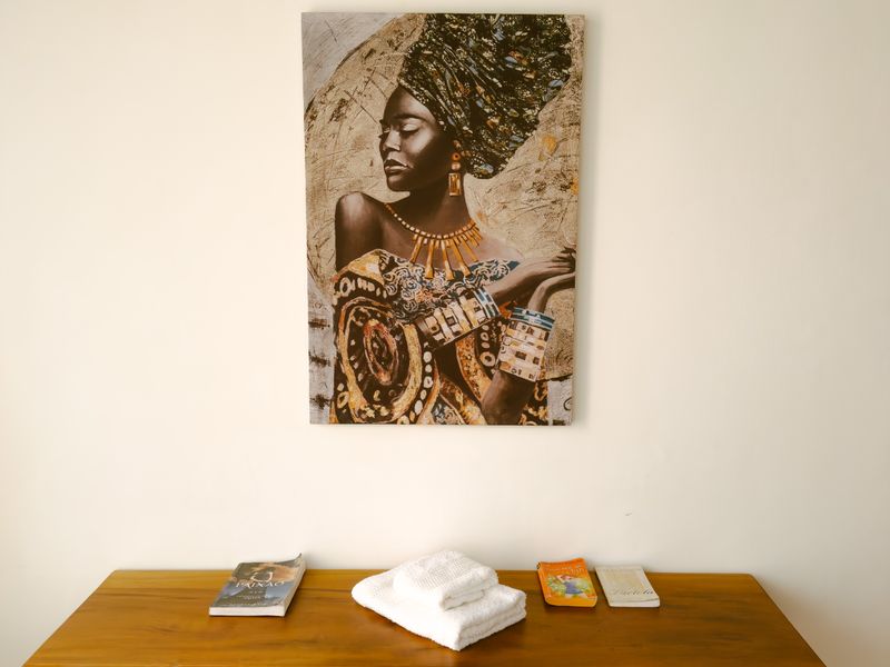Painting of an African woman above a wood desk