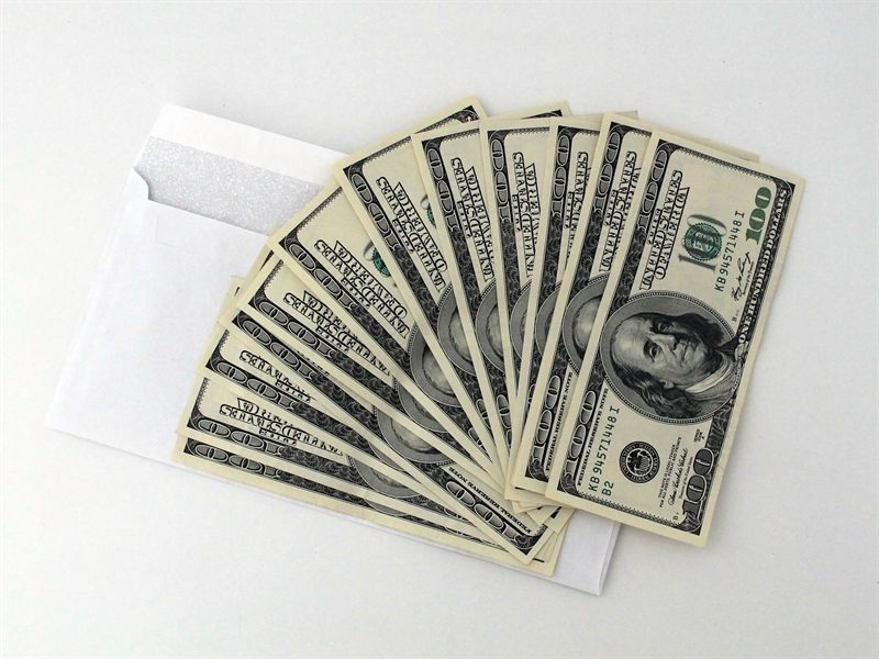 Fan of cash coming out of an envelope