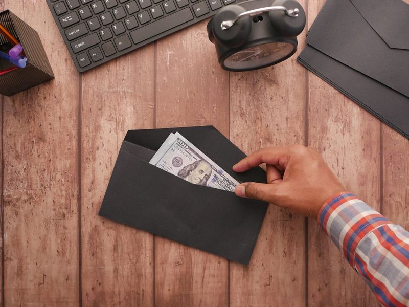 Hand slipping a bill into an envelope