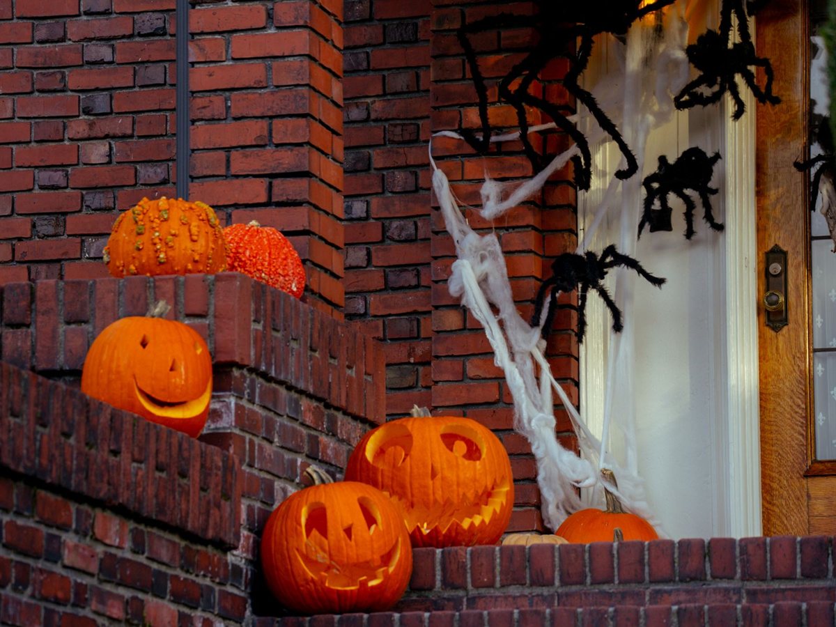 Jack-o'-lanterns and spiders on brick porch steps