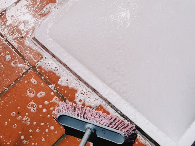 Scrub brush cleaning soapy tiles