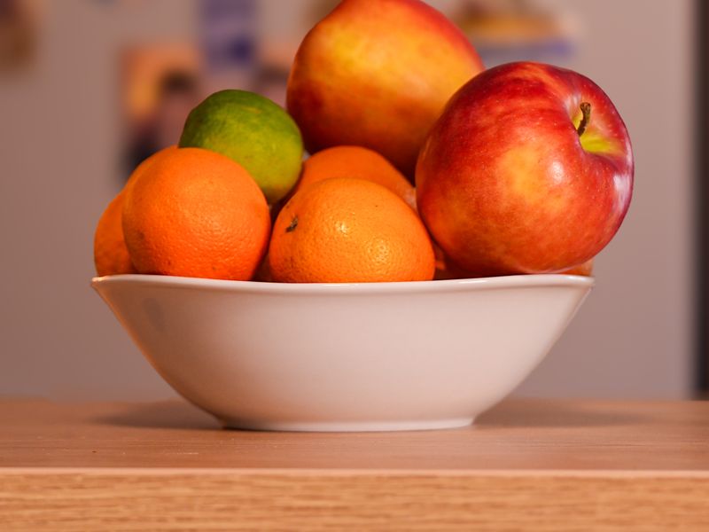 Bowl of apples and oranges on a counter