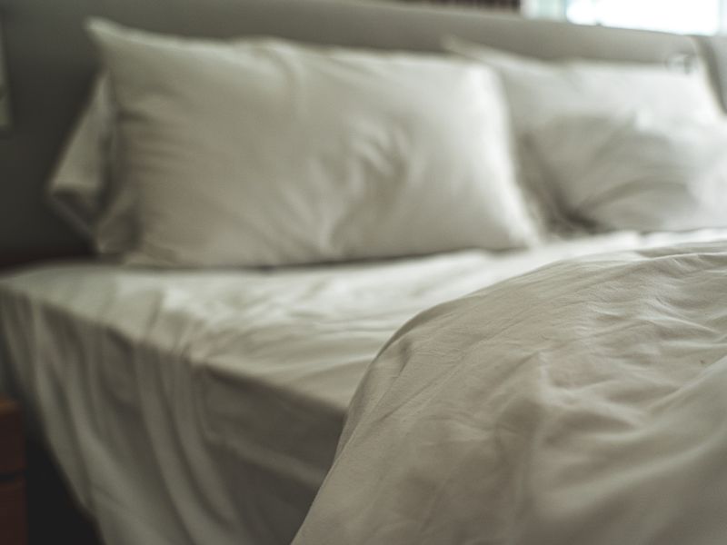 Bed made with soft white sheets