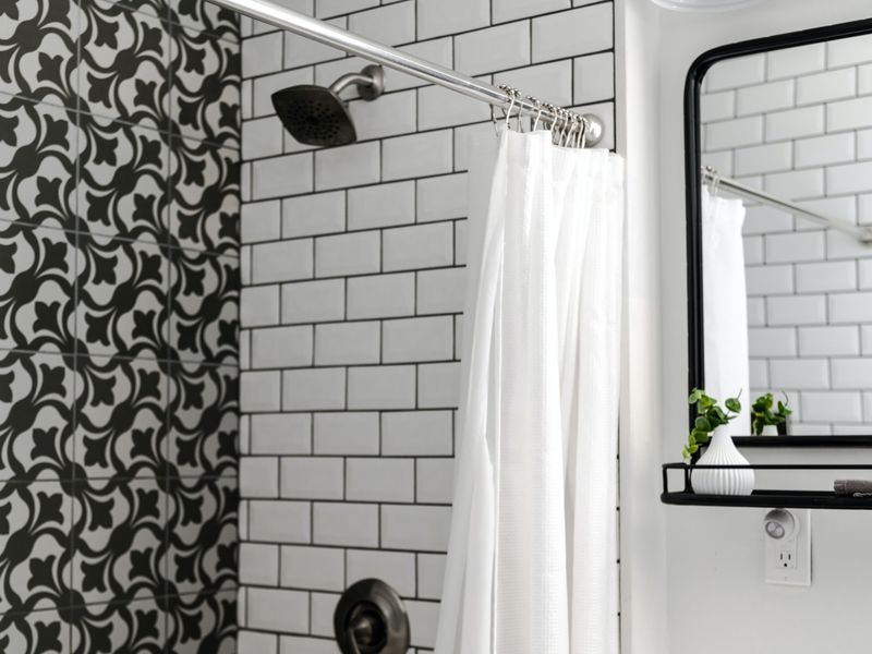 White shower curtain in a tiled bathroom