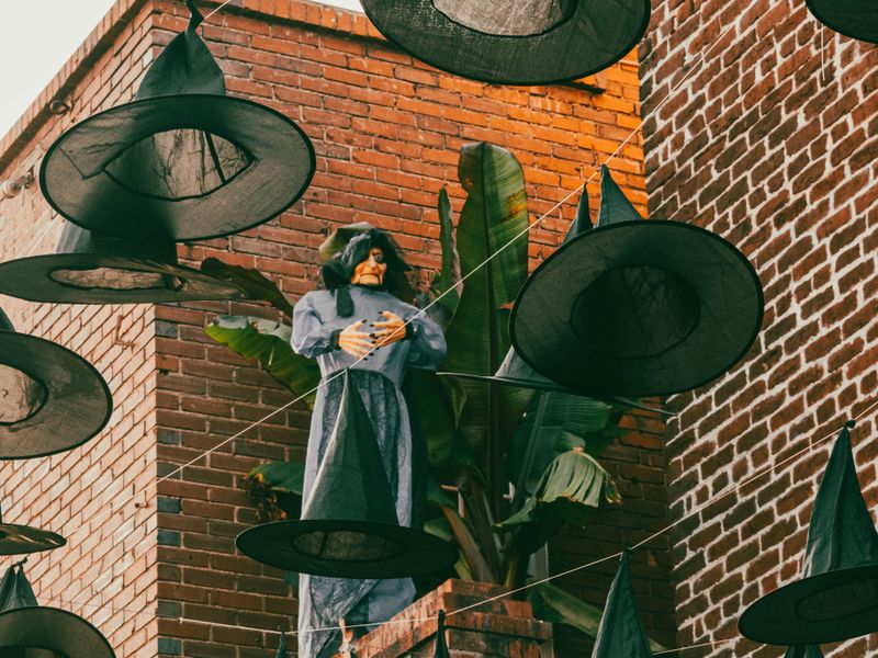 Witch hats hanging above a brick wall