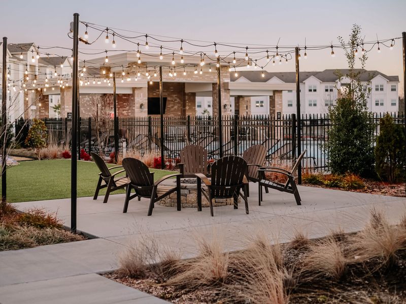 Patio string lights glowing over outdoor chairs at dusk